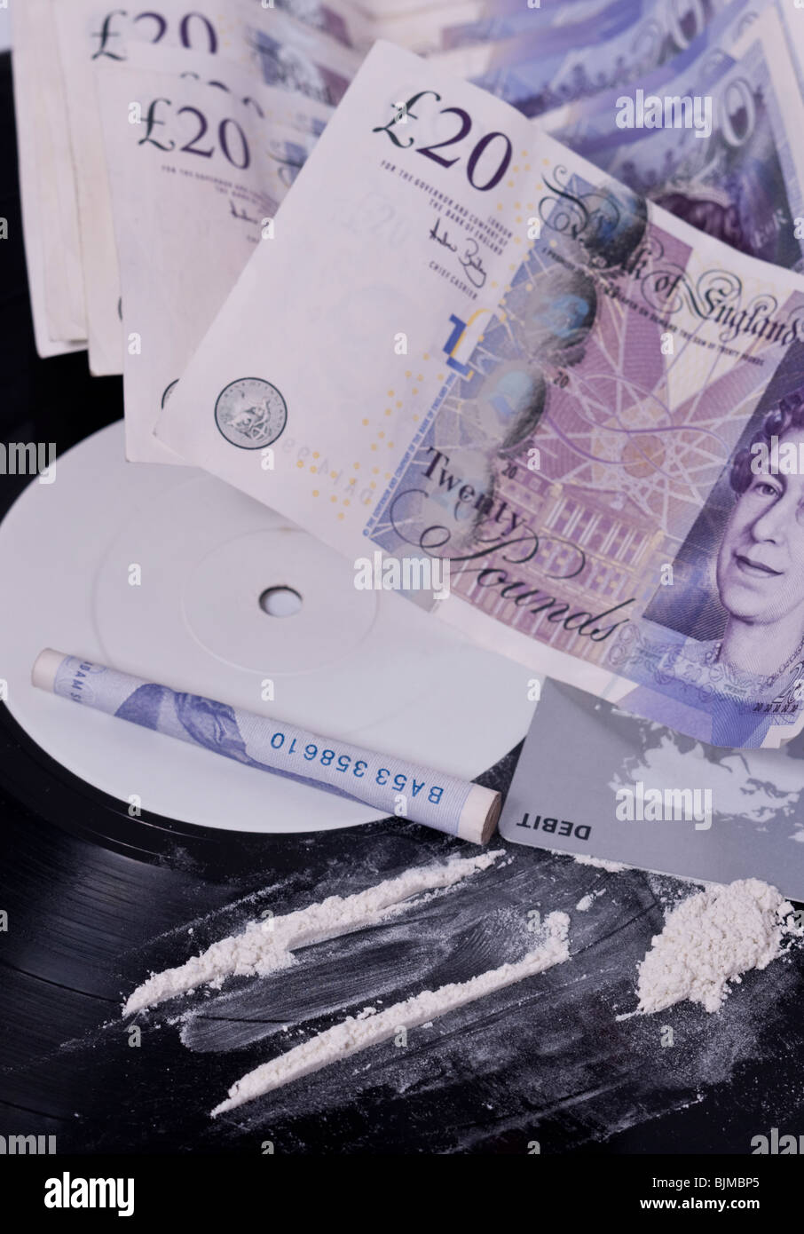 Une photo montrant l'usage de la cocaïne dans l'industrie de la musique avec des lignes de poudre blanche sur une étiquette blanche notice et de l'argent au Royaume-Uni Banque D'Images