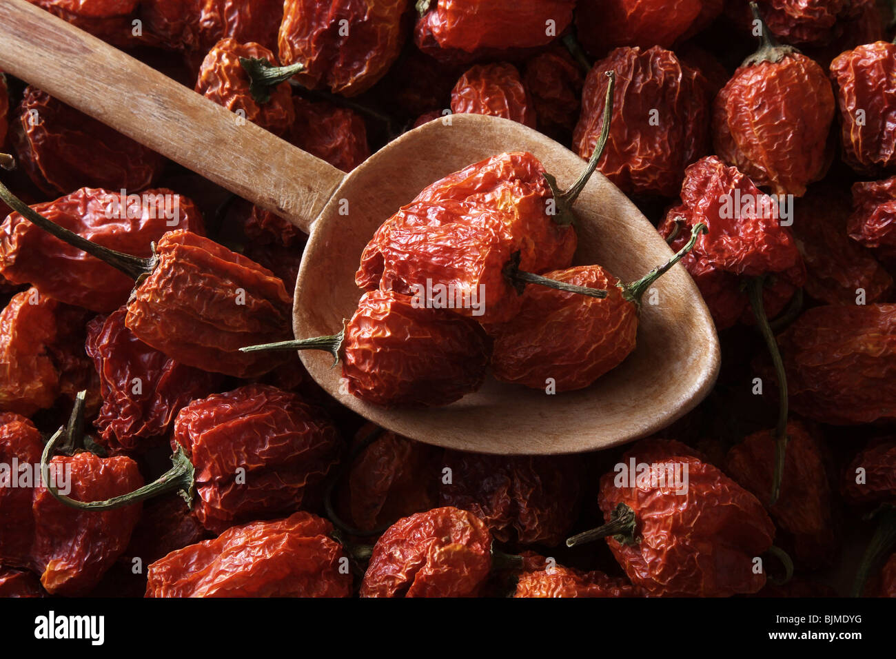 Mini-Peppers (Capsicum) avec une vieille cuillère en bois Banque D'Images