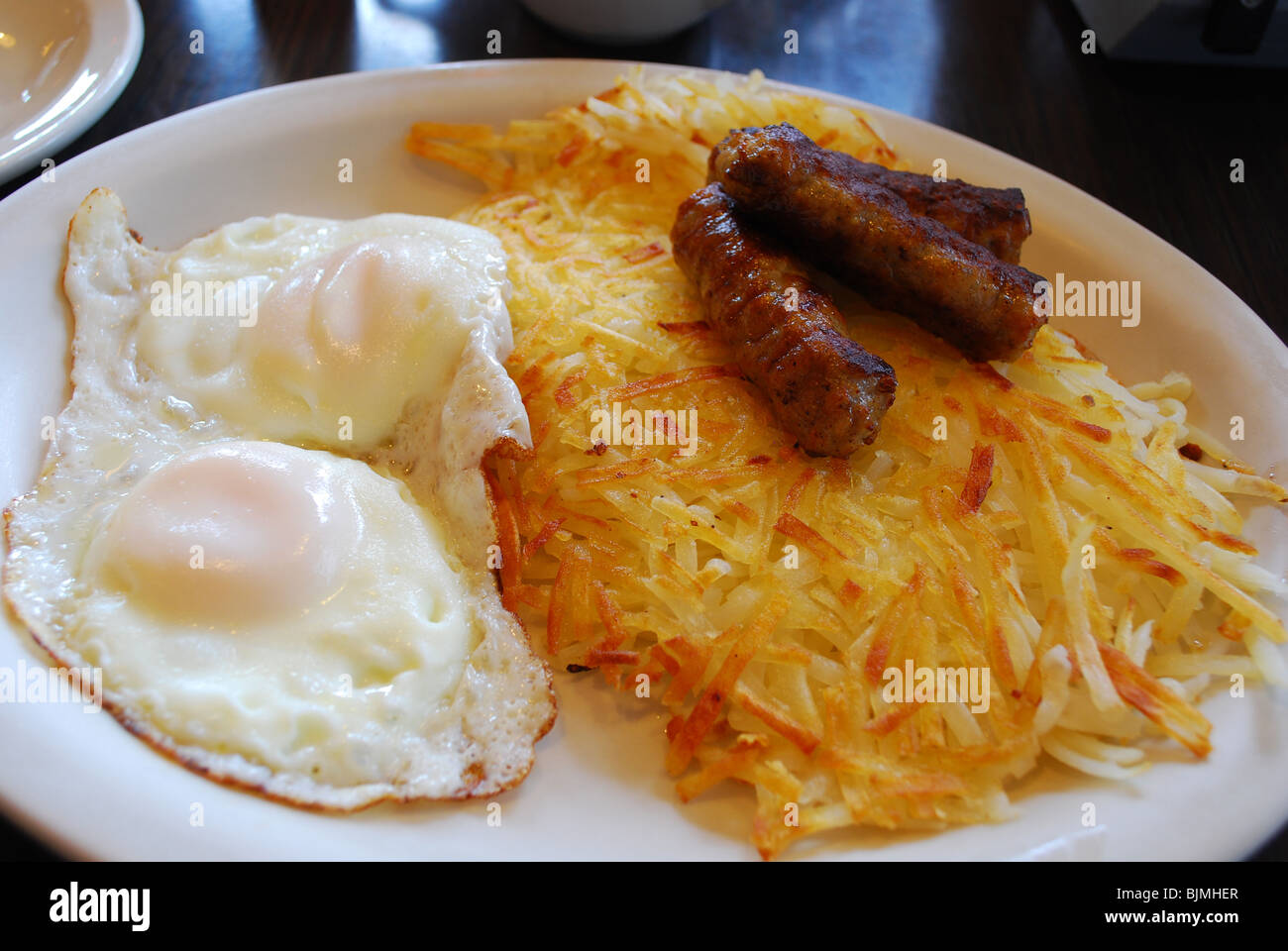 Petit-déjeuner américain typique de deux œufs, saucisses et pommes de terre rissolées Banque D'Images