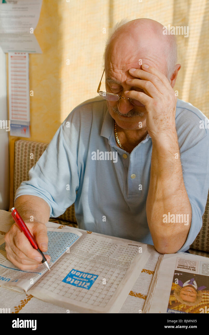Pensionné résoudre des énigmes dans un magazine Banque D'Images
