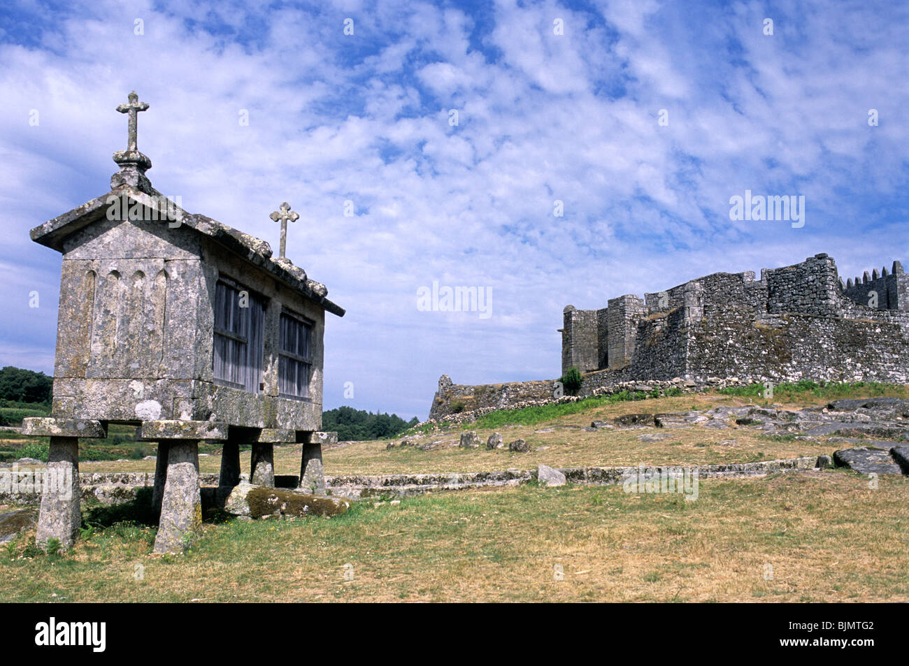Espigueiros traditionnelles, ou les greniers, de Lindoso, nord du Portugal. La ville, château du xiiie siècle est à l'arrière-plan. Banque D'Images