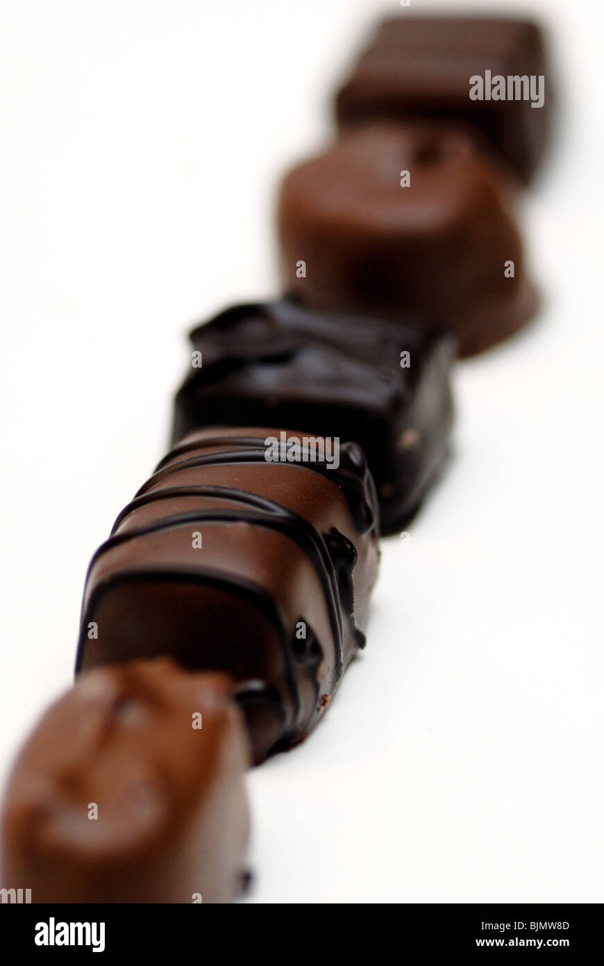 Une variété de bonbons au chocolat noir et au lait alignés dans une rangée avec une faible profondeur de champ Banque D'Images