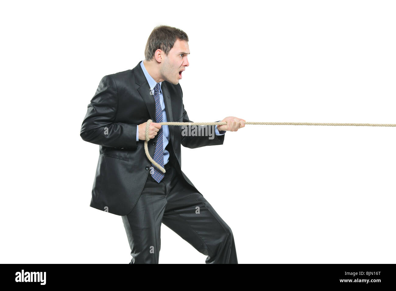 Un jeune homme tirant une corde isolé sur fond blanc Banque D'Images Un jeune homme tirant une corde isolé sur fond blanc Banque D'Images