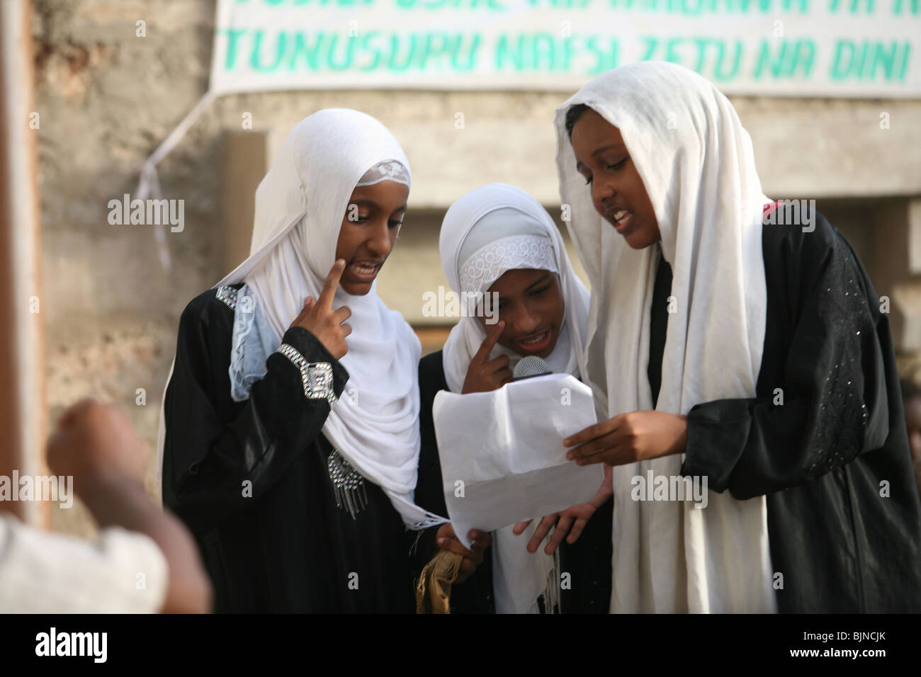 Certaines femmes Swahili portant des foulards traditionnels lecture pendant la traditionnelle fête Maulidi Banque D'Images