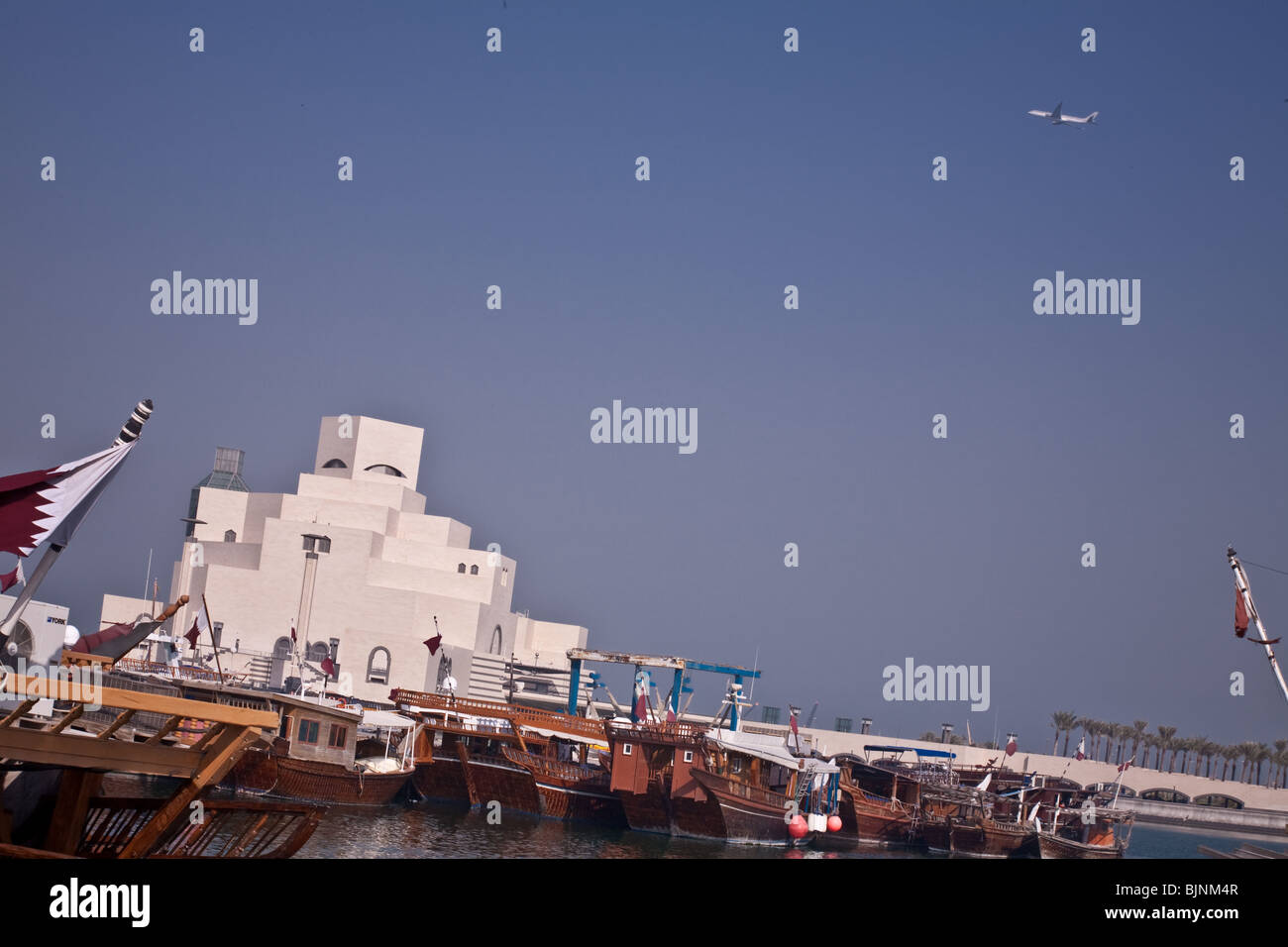 Musée d'Art islamique de Doha, Qatar, avec drapeau national, boutre de pêche et de jet airliner Banque D'Images