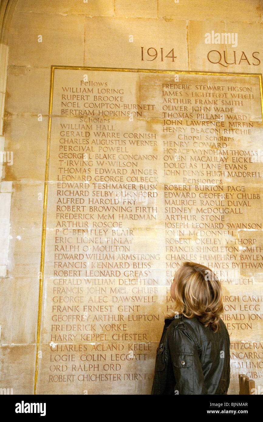 Un touriste regardant les noms des morts de la Première Guerre mondiale, y compris le poète Rupert Brooke, Kings College, Cambridge UK Banque D'Images