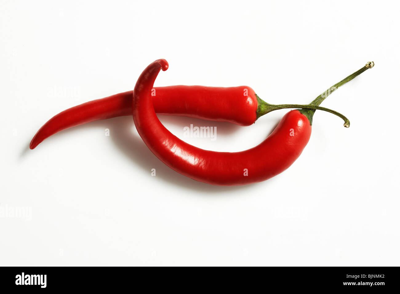 Parfaitement frais red hot peppers sur blanc. Le fichier comprend un chemin de détourage. Retouchées par des images de haute qualité. Banque D'Images