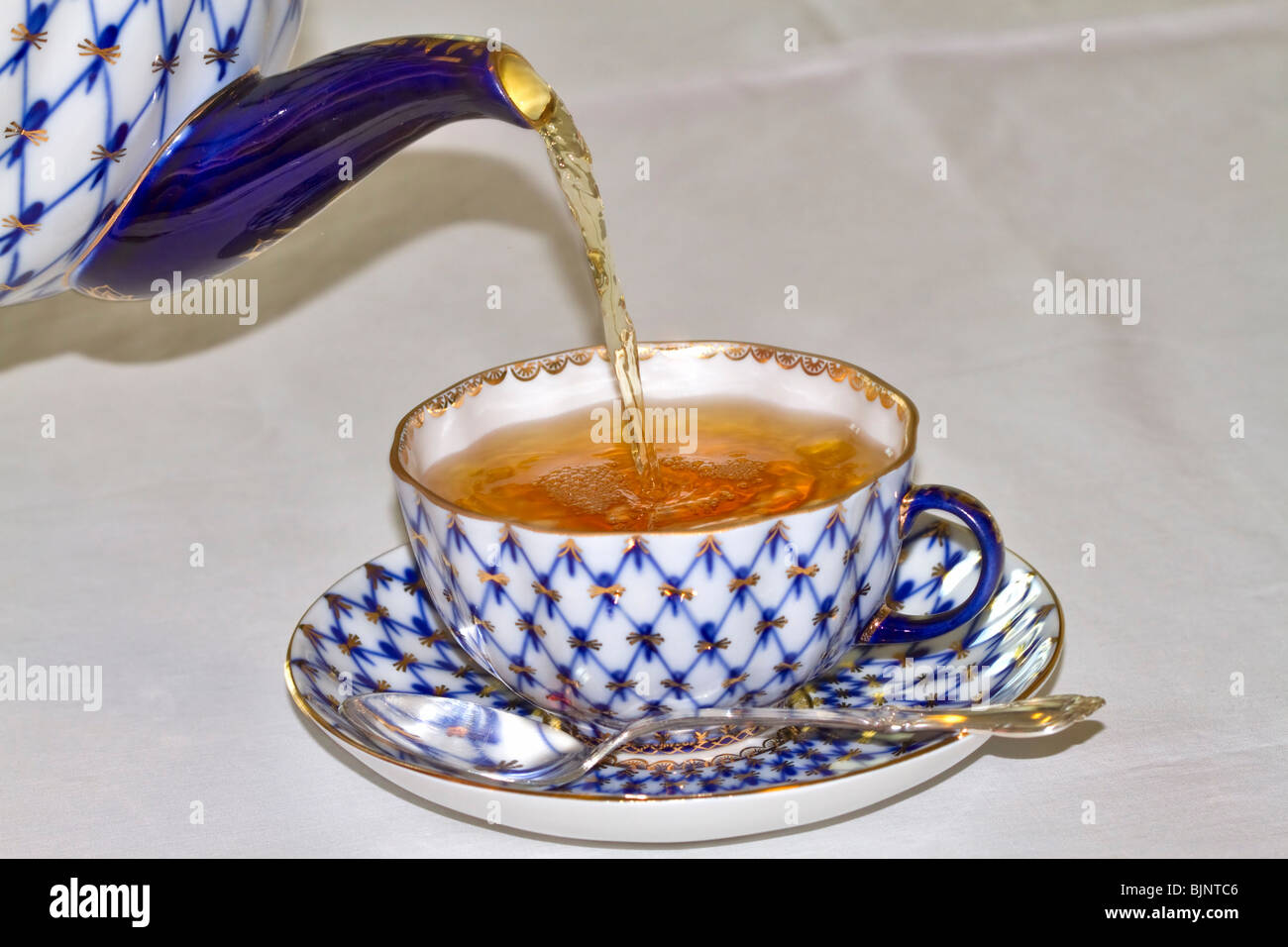Une tasse de thé versé d'une théière Banque D'Images