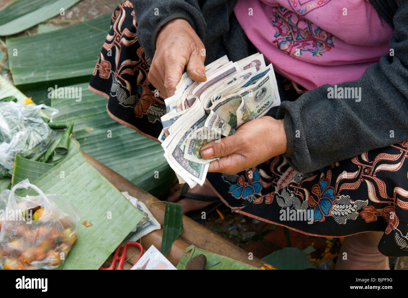 Kip Lao comptant au cours du marché à Luang Prabang au Laos Banque D'Images