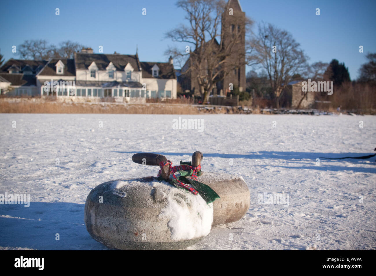 Pierres de curling sur le lac gelé recouvert de neige Banque D'Images