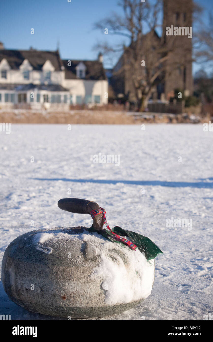 Pierres de curling sur le lac gelé recouvert de neige Banque D'Images