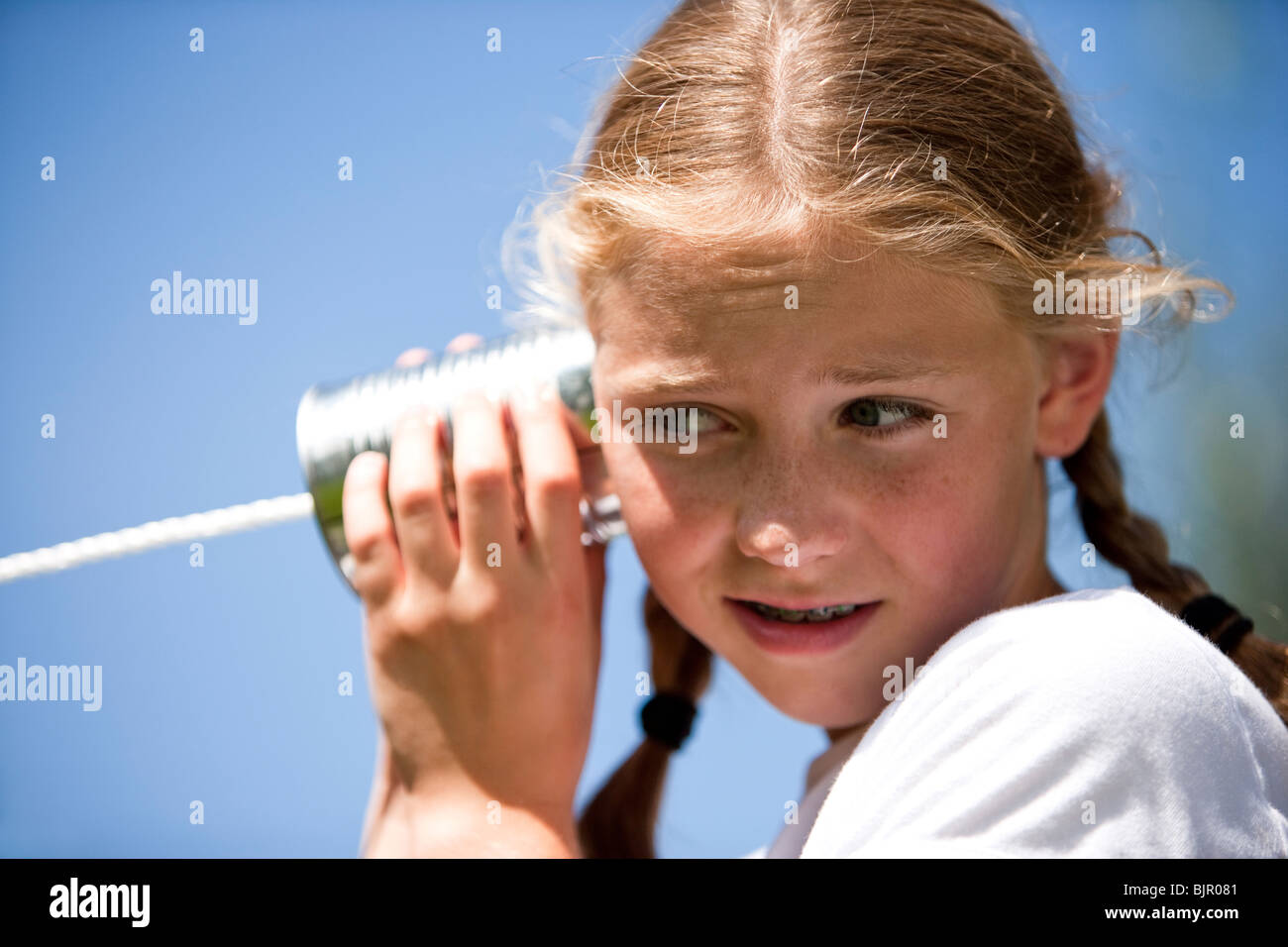 Petite fille jouant avec tin can phone Banque D'Images