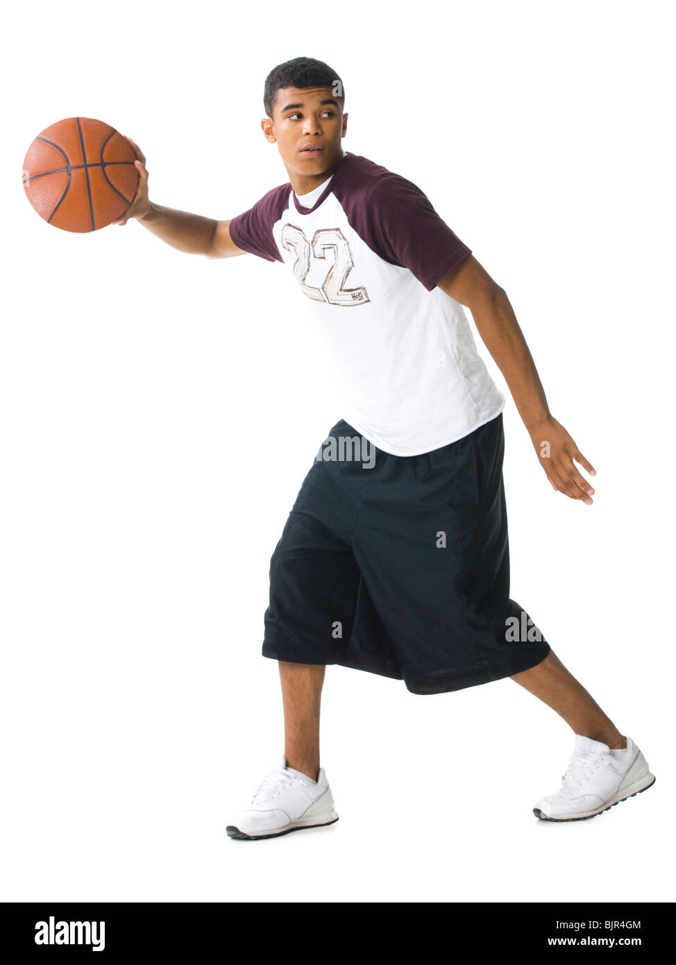 Teenage boy dribbler un ballon de basket-ball Banque D'Images