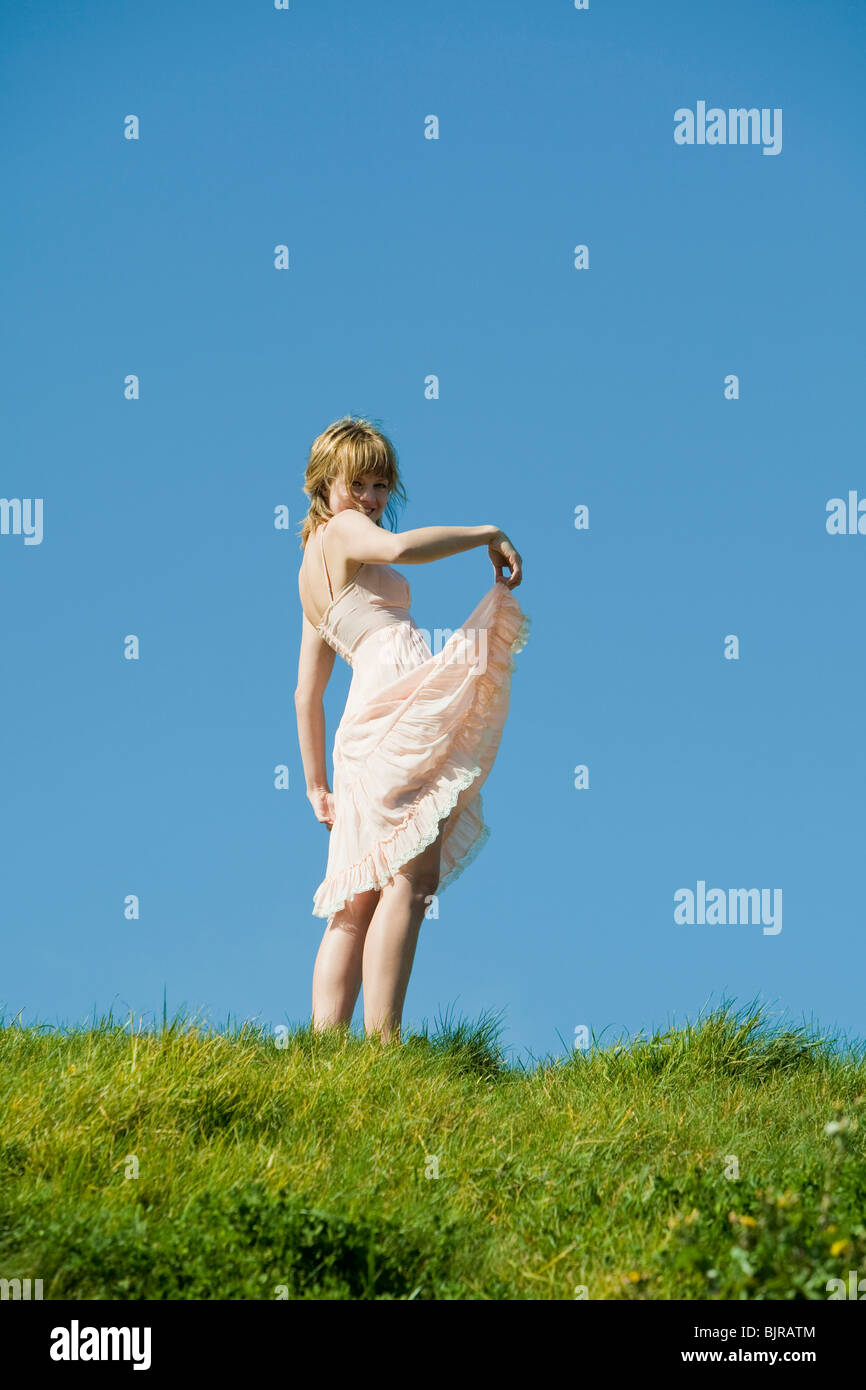 Etats Unis, San Francisco, Californie, young woman standing on grassy hill Banque D'Images
