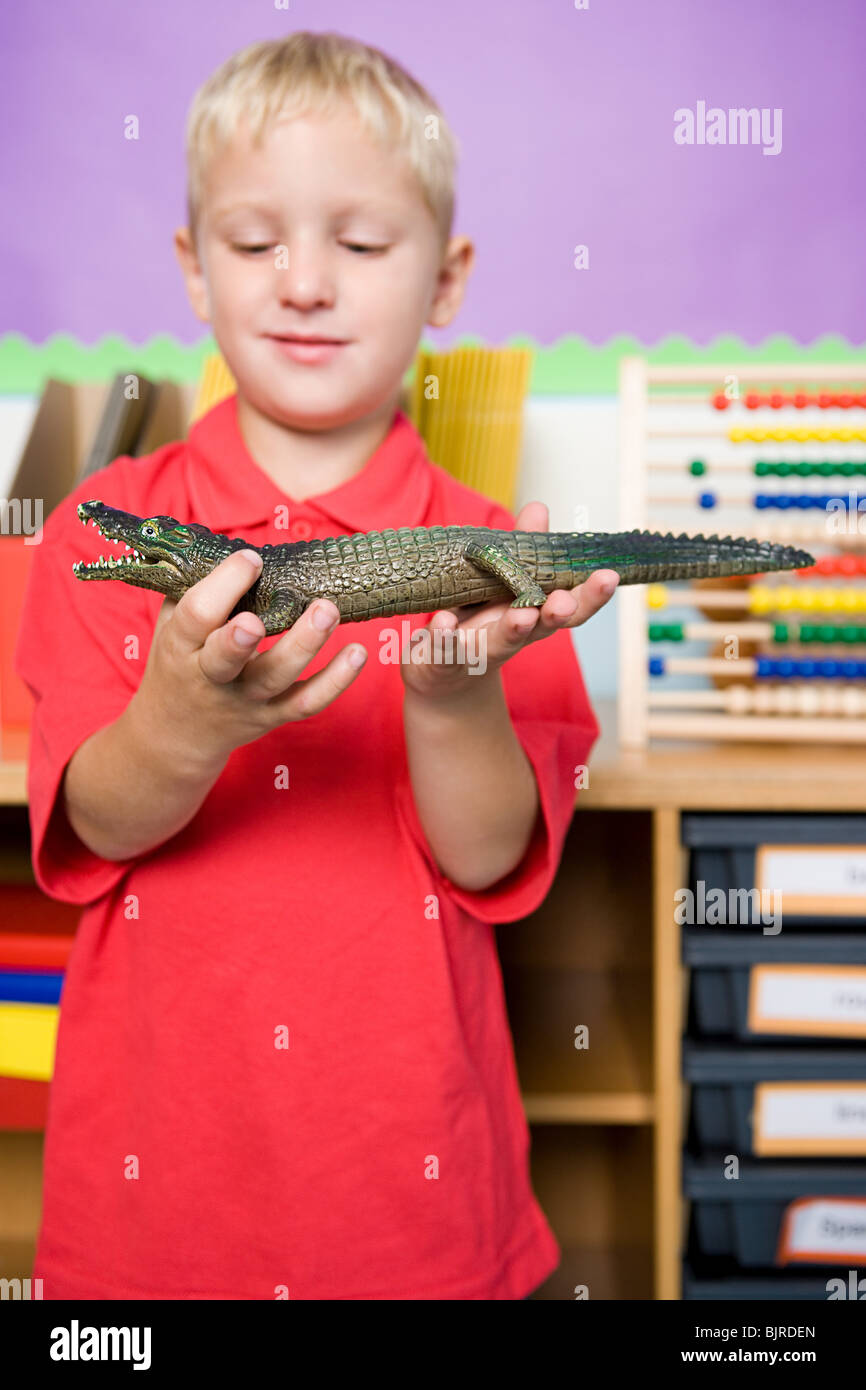 Boy holding toy crocodile Banque D'Images