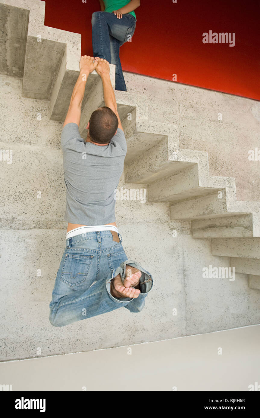 L'homme accroché sur escalier en béton Banque D'Images