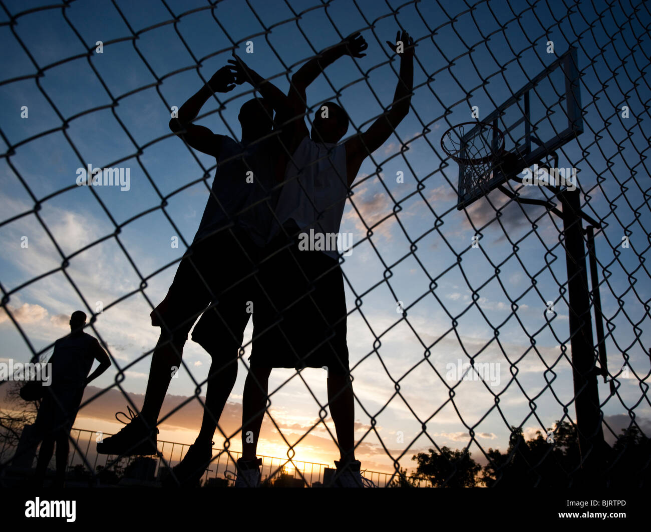 USA, Utah, Salt Lake City, trois jeunes hommes jouant au basket-ball de rue, low angle view Banque D'Images