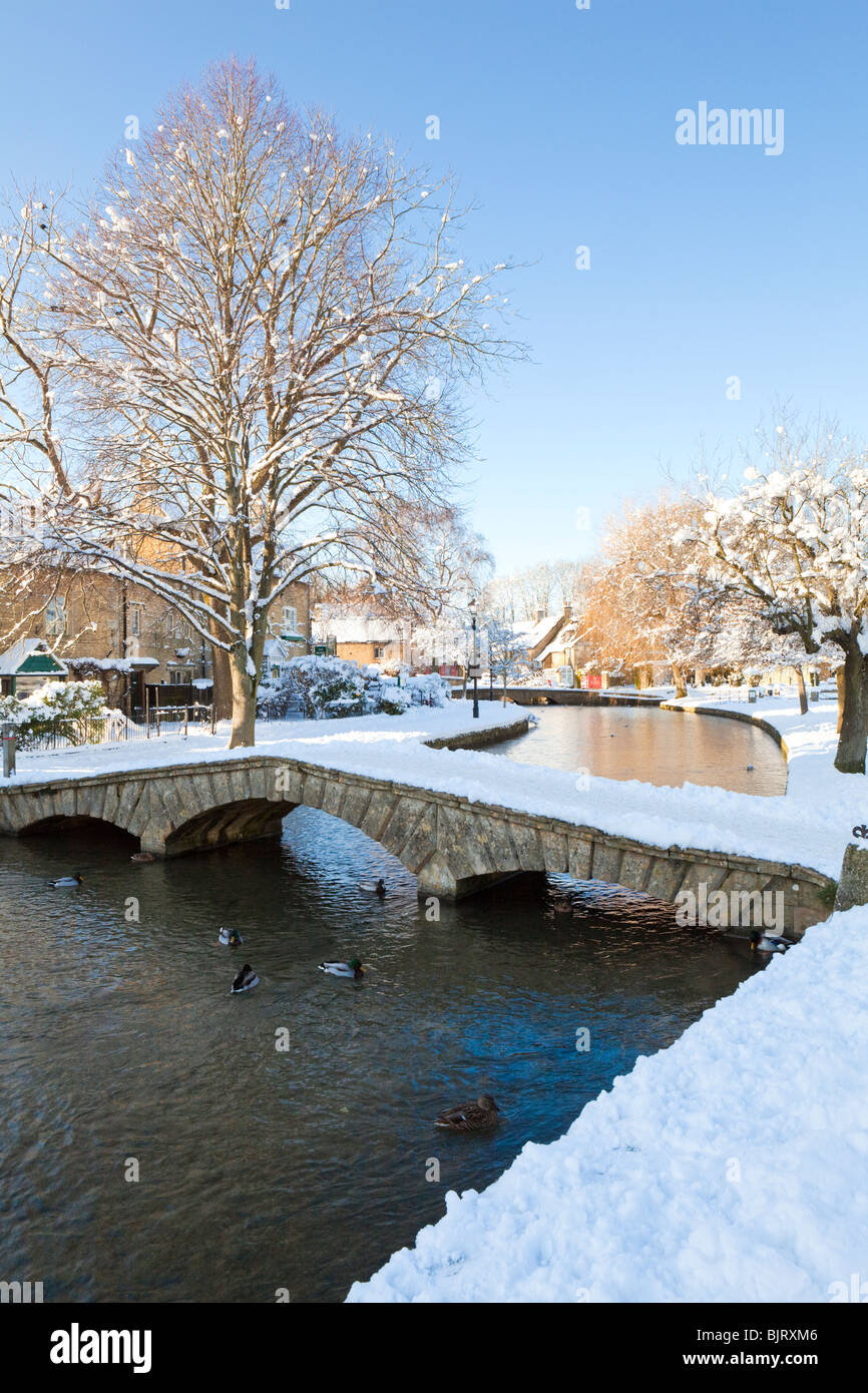 Neige d'hiver sur l'un des ponts au-dessus de la rivière Windrush dans le village de Bourton on the Water de Cotswold, Gloucestershire, Royaume-Uni Banque D'Images