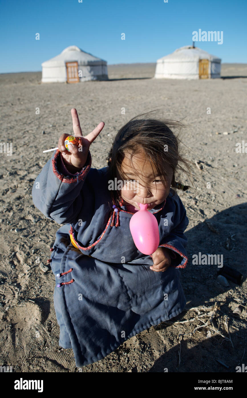 Fille mongole d'exploser un ballon en désert de Gobi, en Mongolie. Banque D'Images