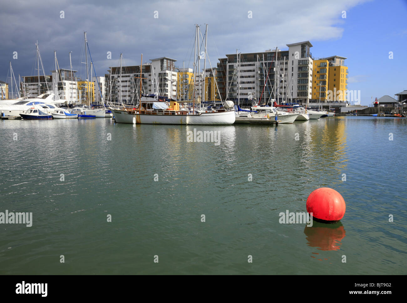 Bateaux amarrés devant les appartements modernes de South Harbour, Harbour Marina Souverain, Eastbourne, East Sussex. Banque D'Images