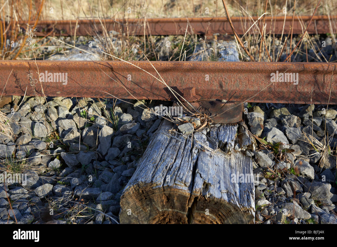 Ancienne grand sud et l'ouest de la ligne de chemin de fer relié à des traverses en bois usé du comté de Sligo en république d'Irlande Banque D'Images