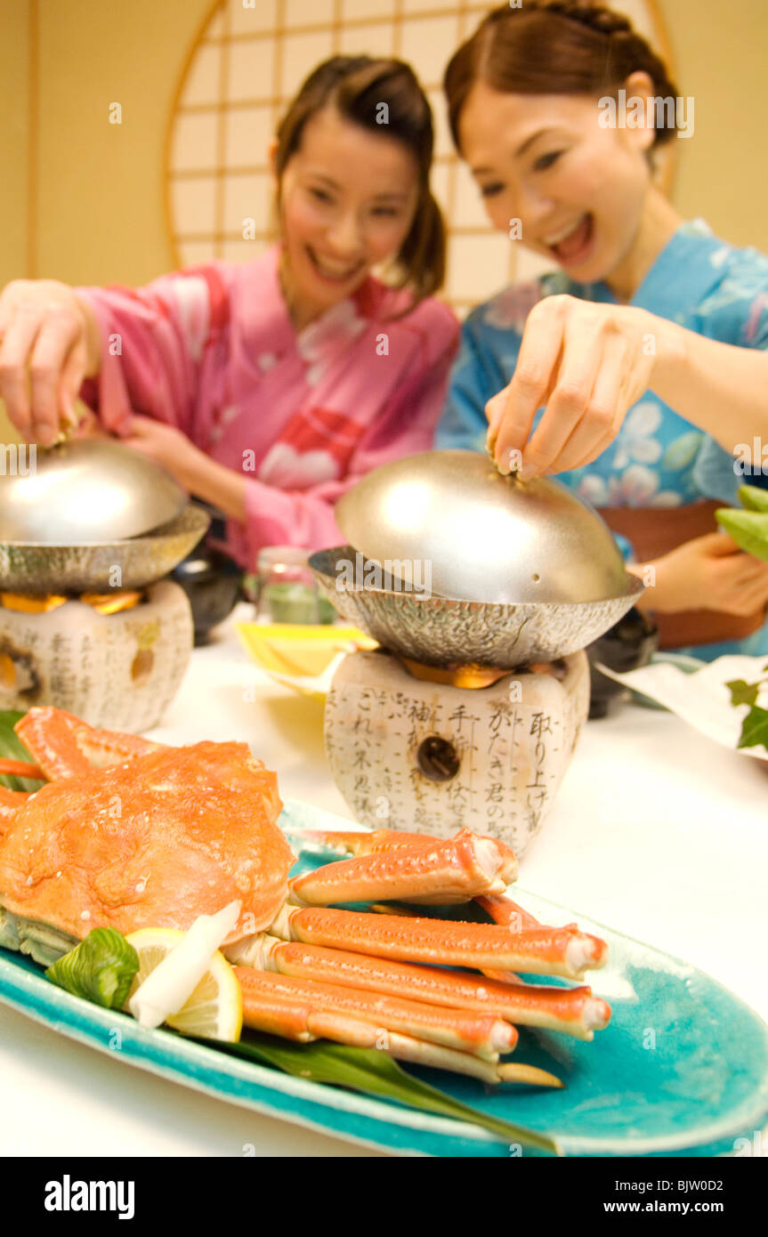 Des femmes habillées en yukatas de s'asseoir pour manger un repas Banque D'Images