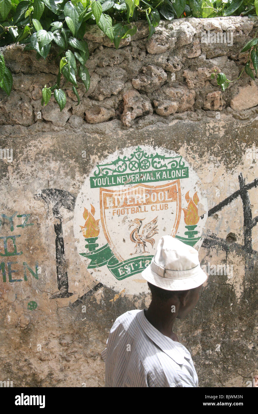 Un homme passe devant un Liverpool Football club inscription peinte sur le mur de la ville de Lamu, Kenya, Afrique de l'Est Banque D'Images