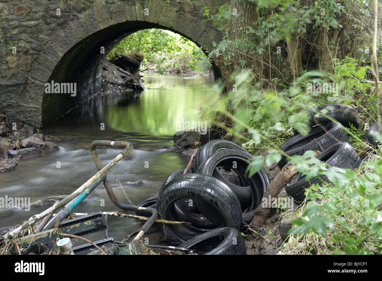 Les déchets jetés dans une rivière. Banque D'Images