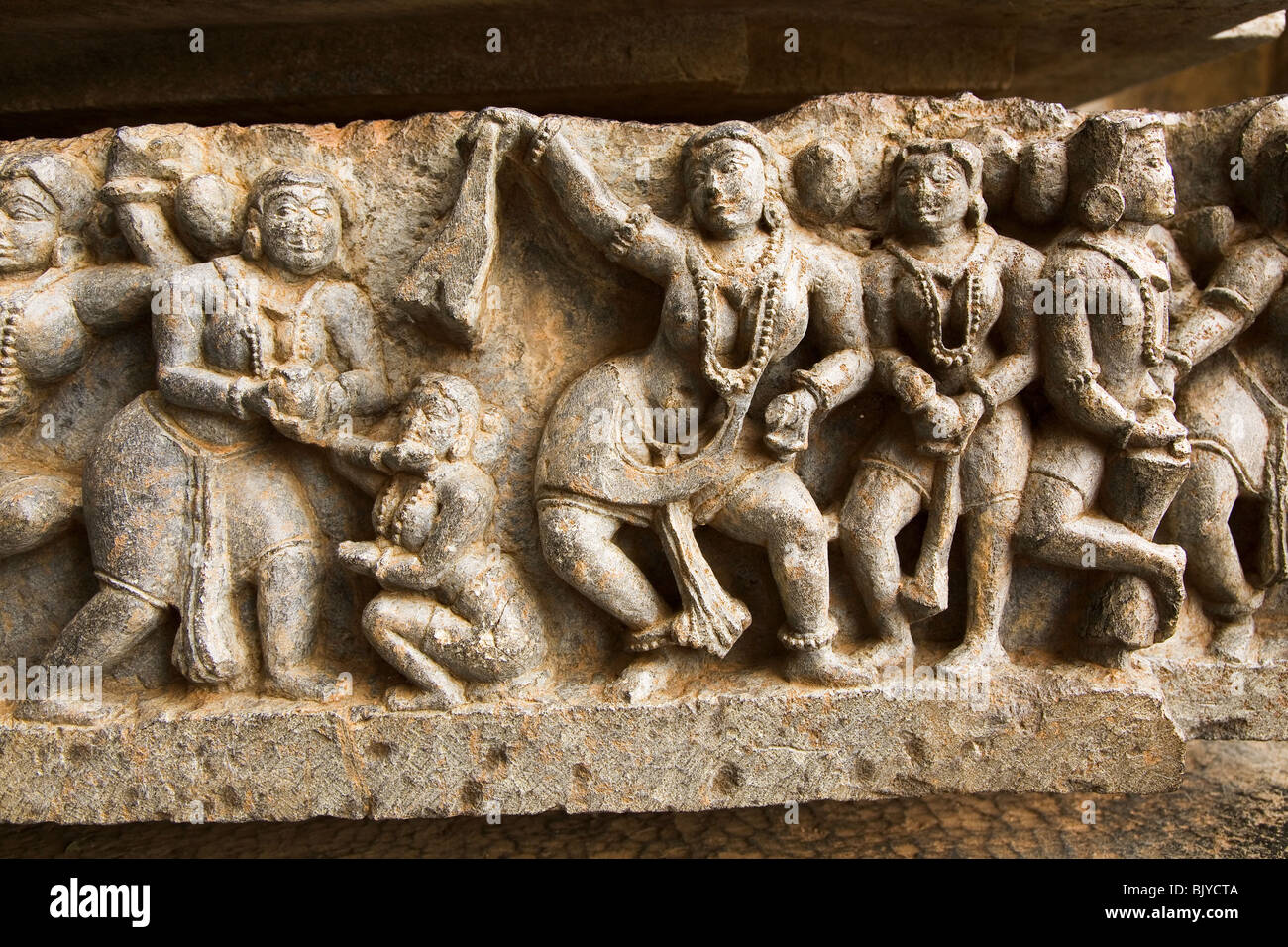 Bas-relief sculpté détail montre des femmes et des divertissements du Hoysaleshvara, Temple Halebid, Inde. Banque D'Images