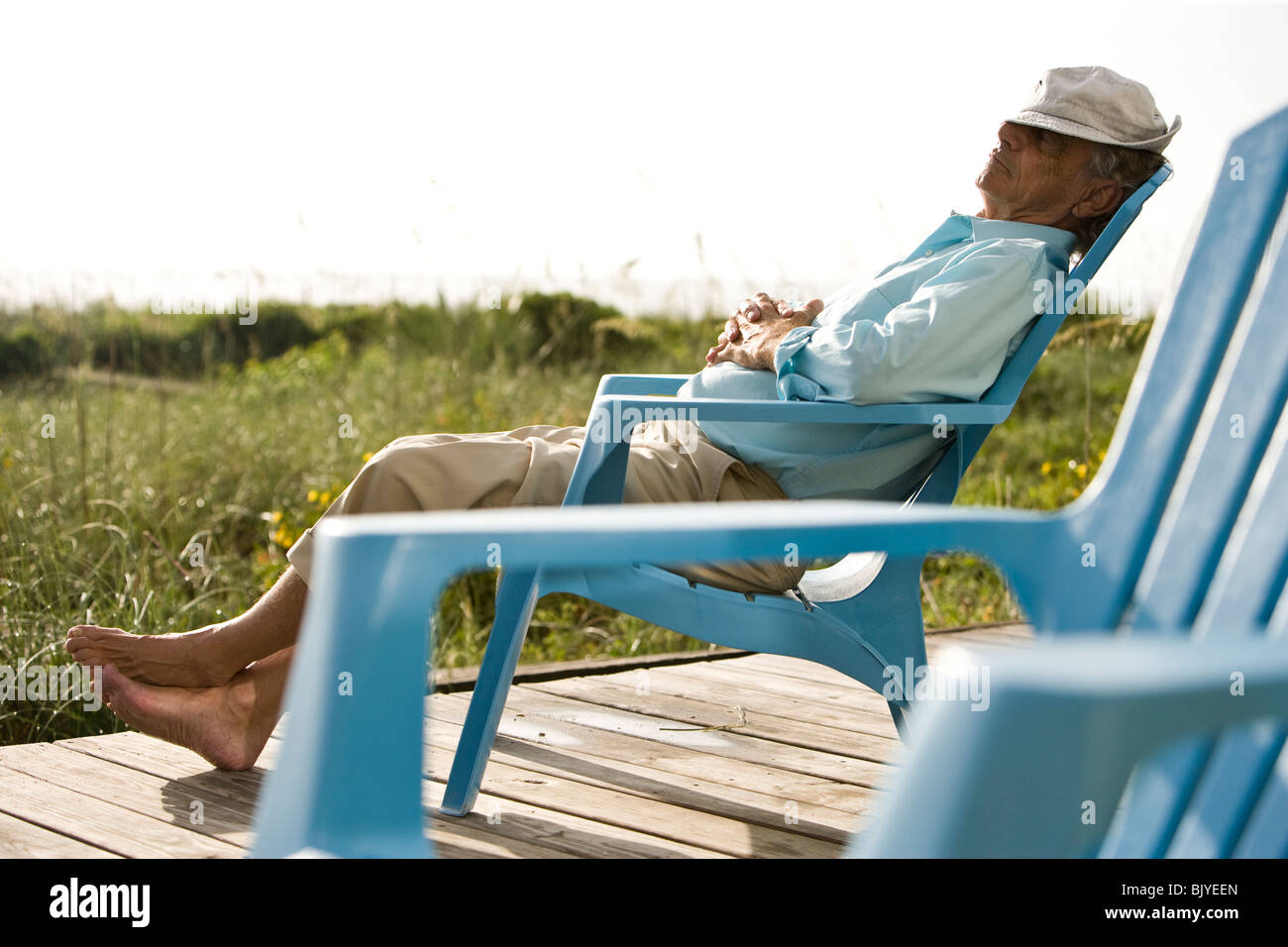Senior Man Sitting On Chair Sieste Au Soleil Sur La Terrasse En Bois Photo Stock Alamy