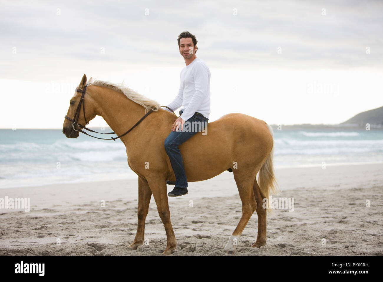 L'homme cheval d'équitation sur la plage Banque D'Images