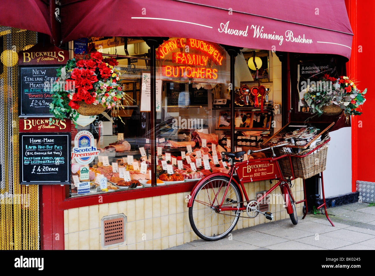 Jeu traditionnel butchers shop avec de vieux vélos de livraison bouchers devant uk southsea Banque D'Images