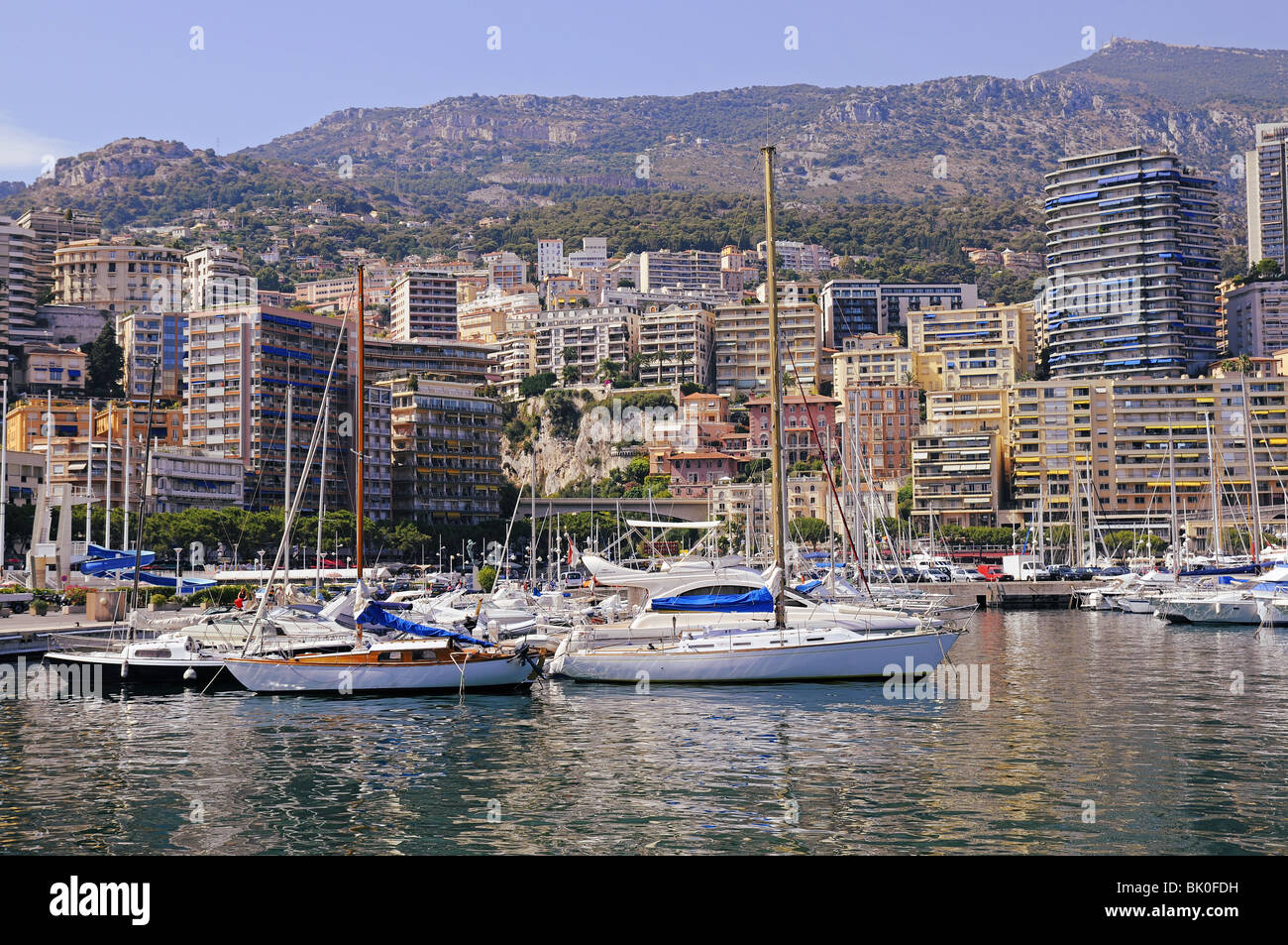 Yachts de luxe et bateaux dans le port de Monaco. Montagnes et bâtiments. Banque D'Images
