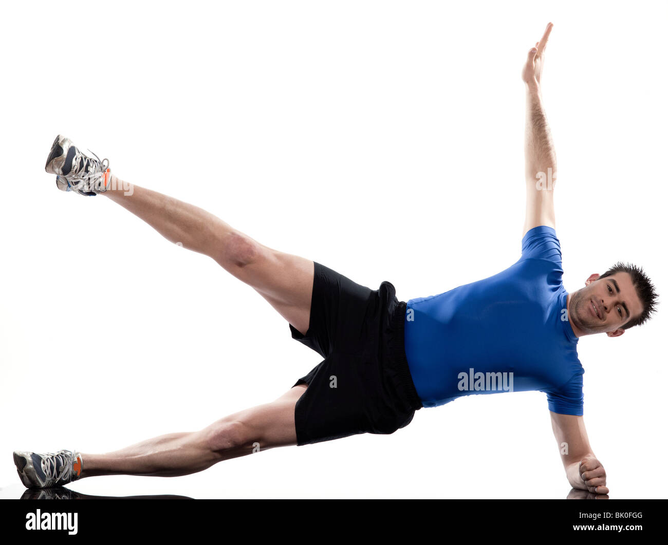 Homme couché sur le côté d'entraînement des abdominaux posture sur studio isolé sur fond blanc Banque D'Images