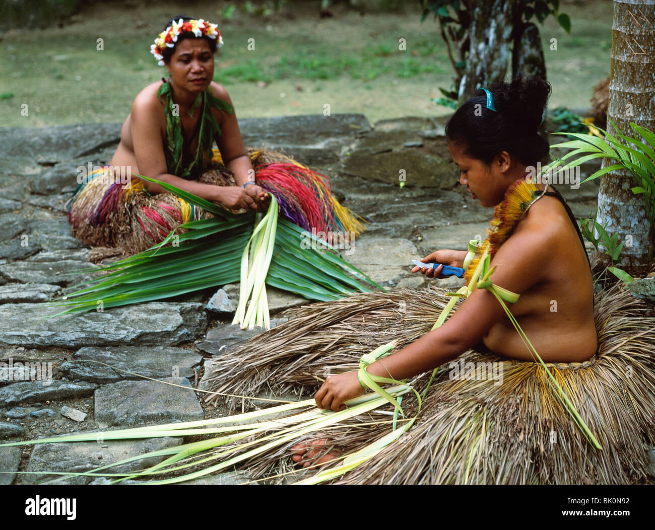 Des femmes enseignant girl pour préparer les feuilles de palmier d'Arec pour jupes, Yap, Micronésie Banque D'Images