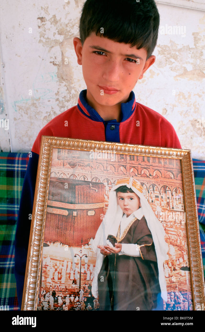 Garçon musulman avec une photo de lui-même visiter la Mecque, Jérusalem, Israël. Banque D'Images