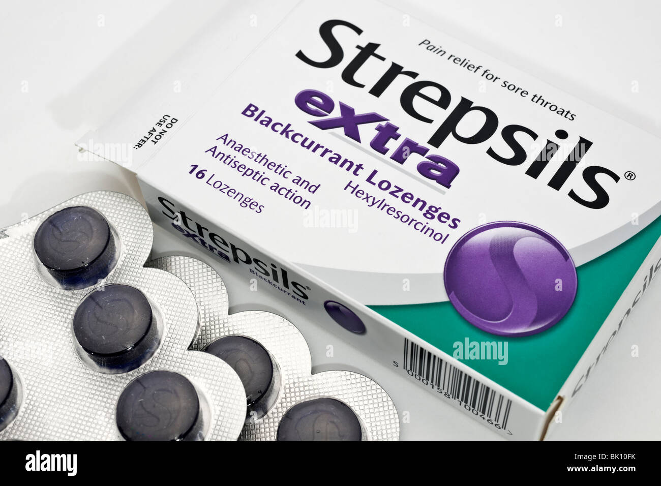 Ouverture de la boîte de Strepsils pastilles cassis Extra pour les maux de gorge Banque D'Images