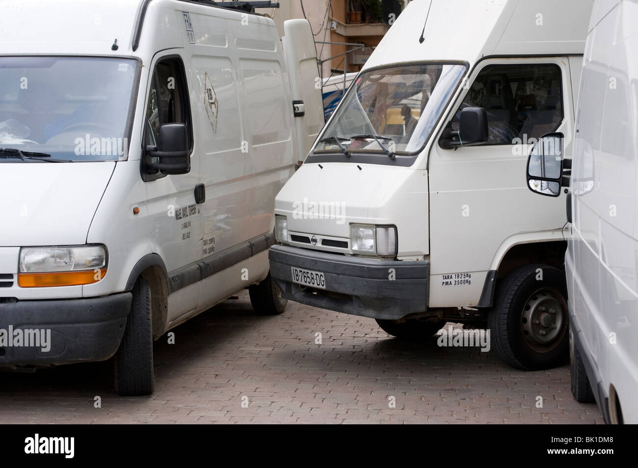 Fourgonnettes blanches mal stationné en Espagne. Banque D'Images