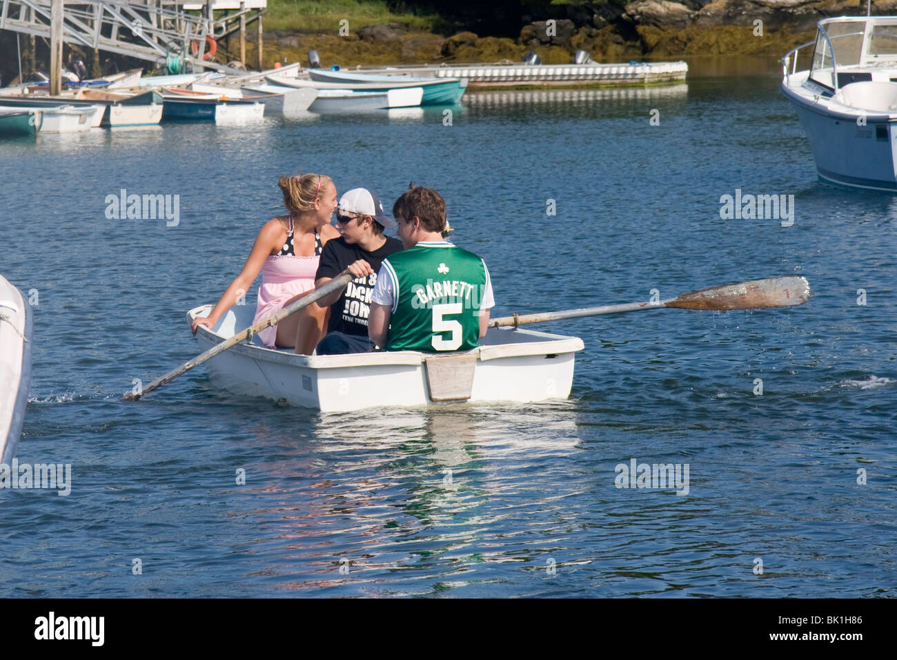 Les jeunes l'aviron à terre dans un canot au Harbor, Maine Banque D'Images