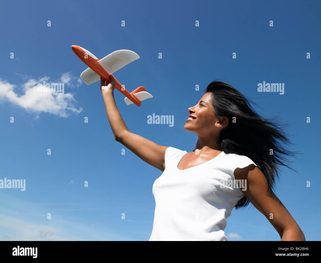 Femme tenant un avion vers le ciel Banque D'Images