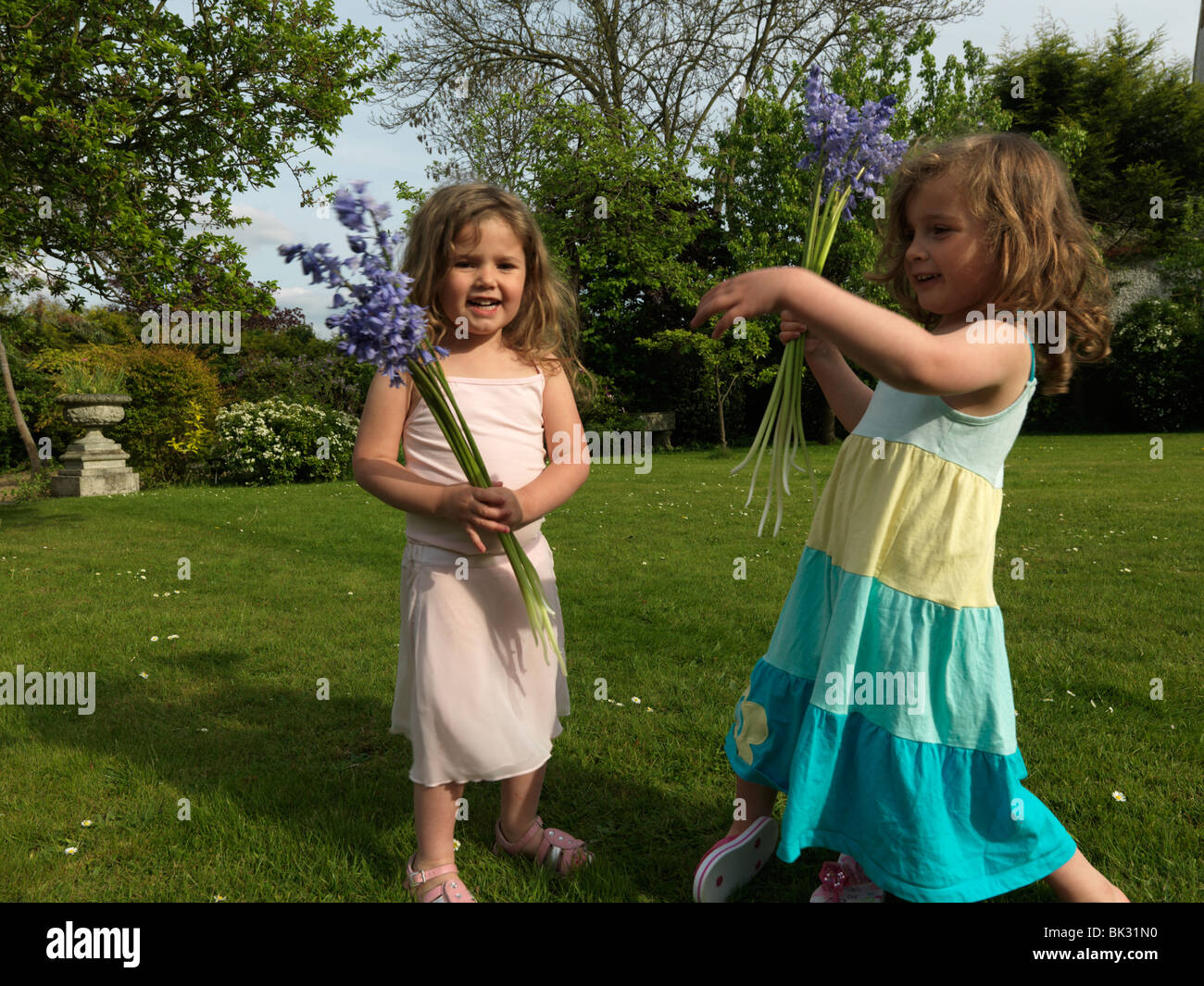 Deux jeunes Sœurs dans jardin avec jacinthes fraîchement cueillies en Angleterre Banque D'Images