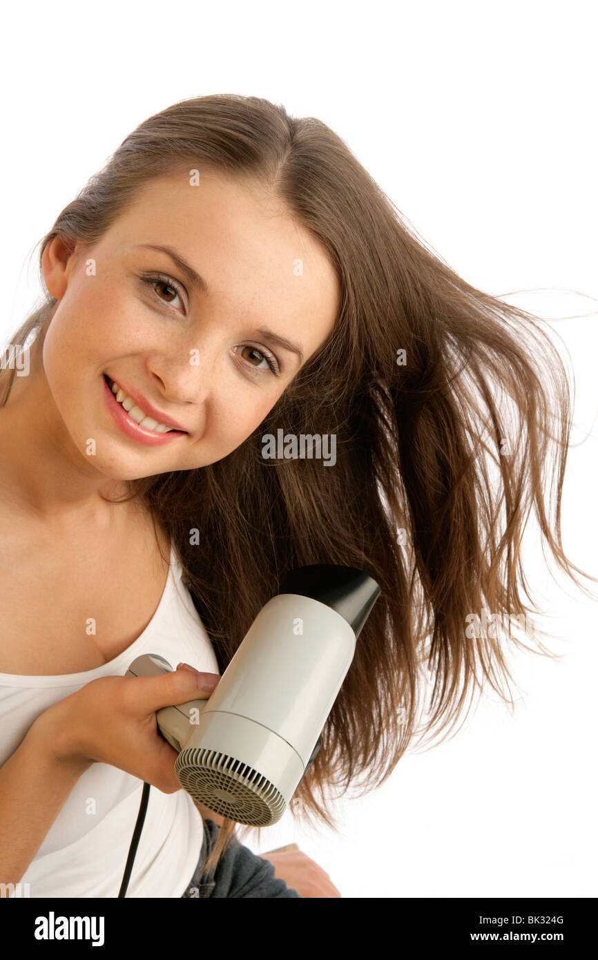 Portrait de jeune femme à l'aide d'un sèche-cheveux isolé sur fond blanc Banque D'Images