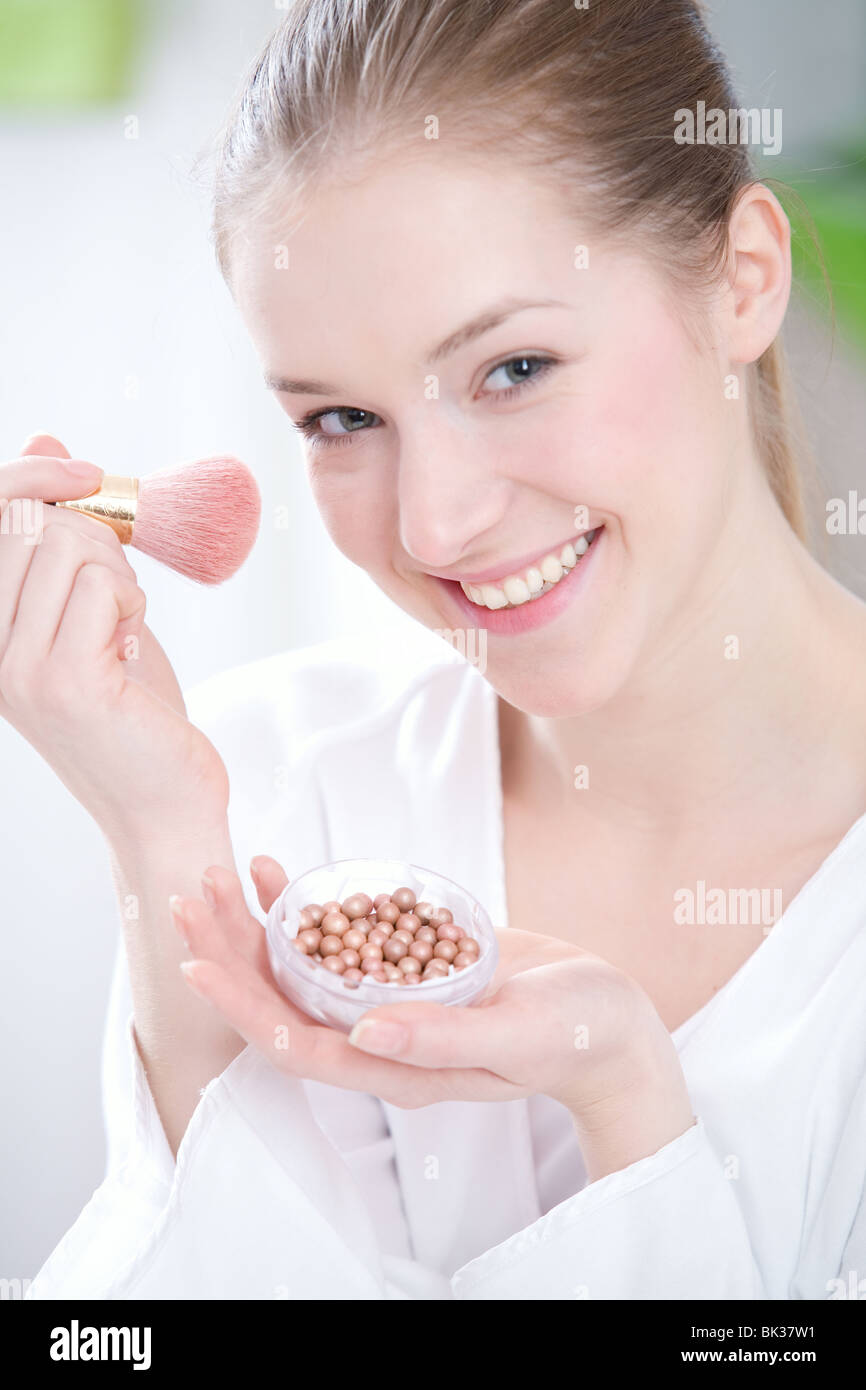 Woman applying blush Banque D'Images