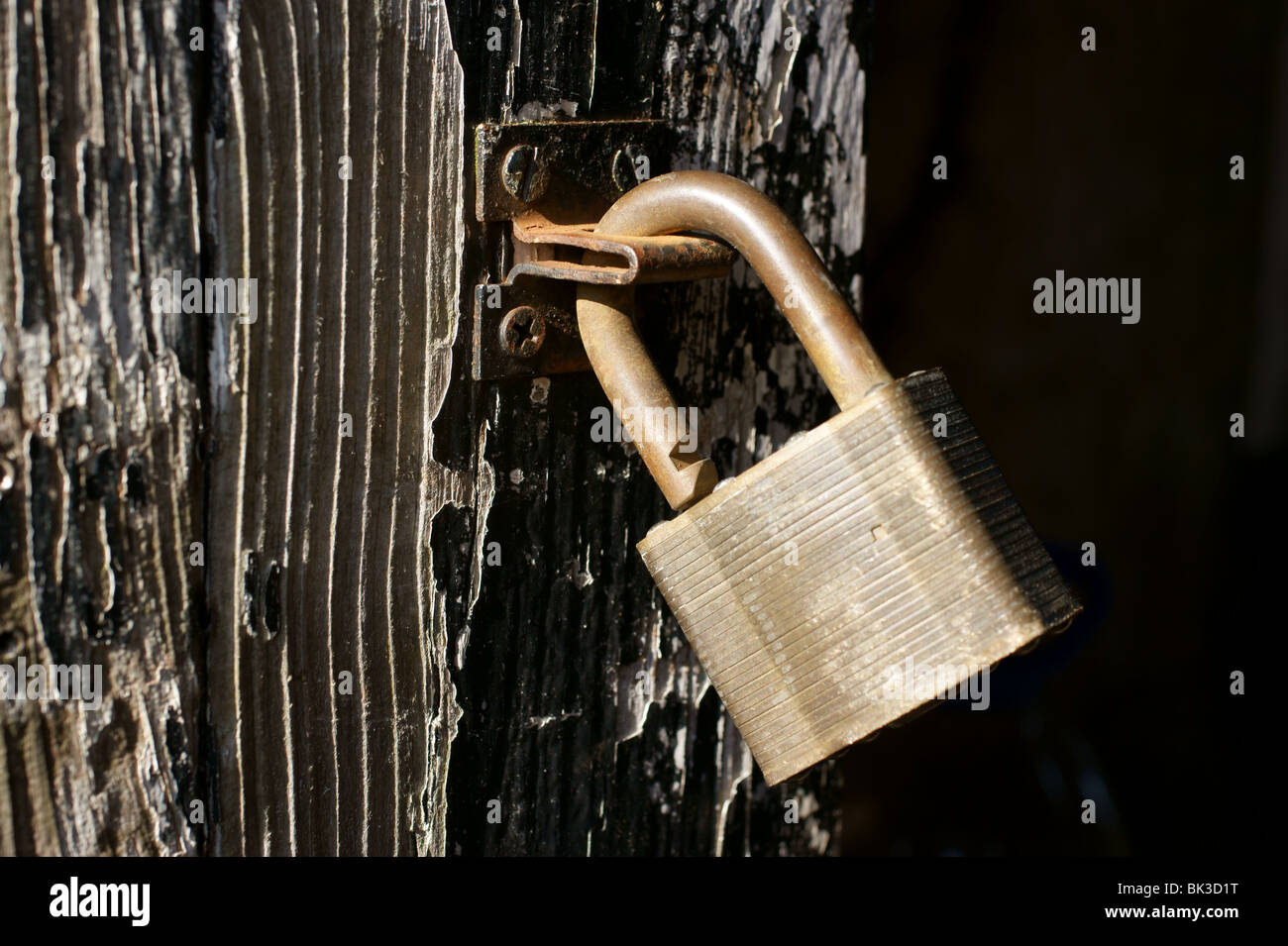 Cadenas déverrouillé sur une vieille porte en bois Banque D'Images