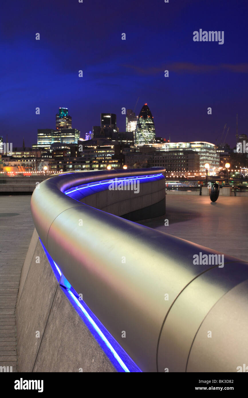 'Plus' London tube en acier inoxydable, la main courante en serpentant la distance vers la Tamise et la Tour de Londres, la nuit. Banque D'Images