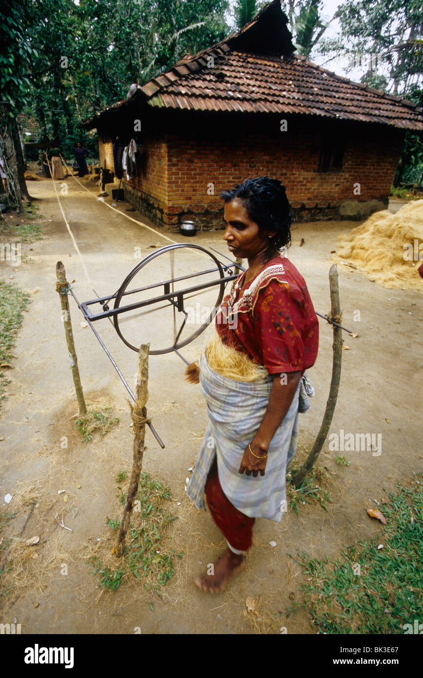 Femme avec la fabrication de cordes en fibre de coco Coco' dans 'façon traditionnelle dans un village d'eau dormante Banque D'Images