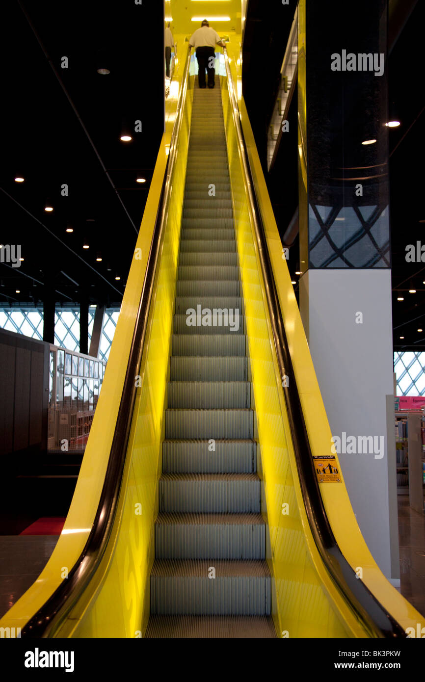 Personne escalade d'un jaune vif à l'intérieur de la succursale du centre-ville d'indexation de la Bibliothèque Publique de Seattle, Seattle, Washington Banque D'Images