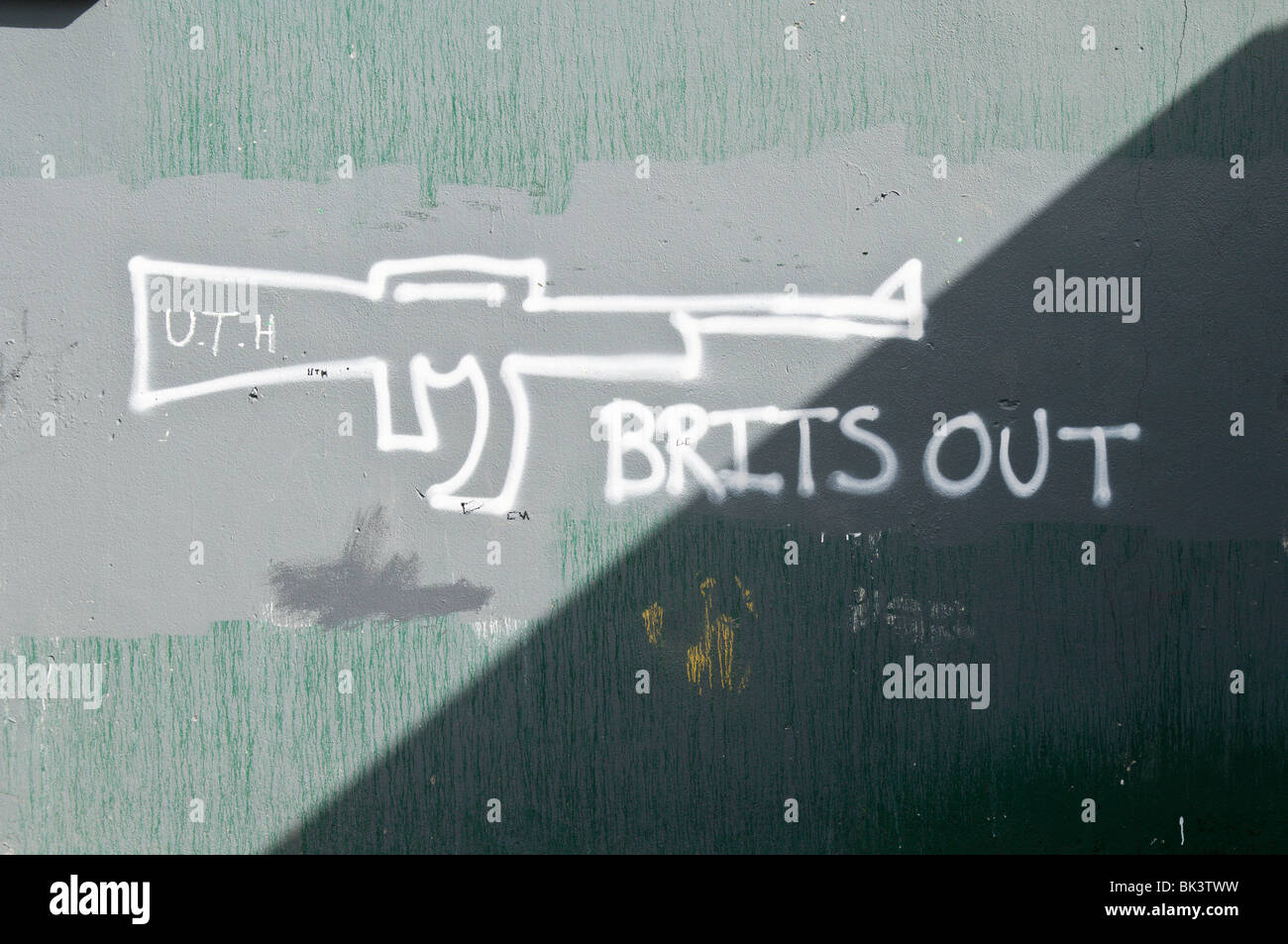 Graffiti sur un mur, 'Brits out' avec un fusil AK-47 Banque D'Images