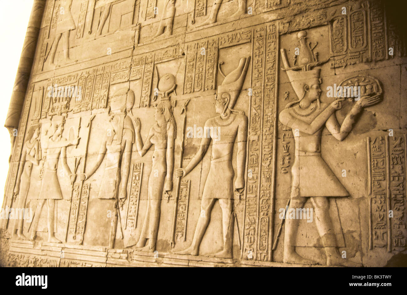Sculpture murale bas-relief représentant des figures humaines et des divinités égyptiennes dans une ancienne ruine, l'Égypte. Banque D'Images