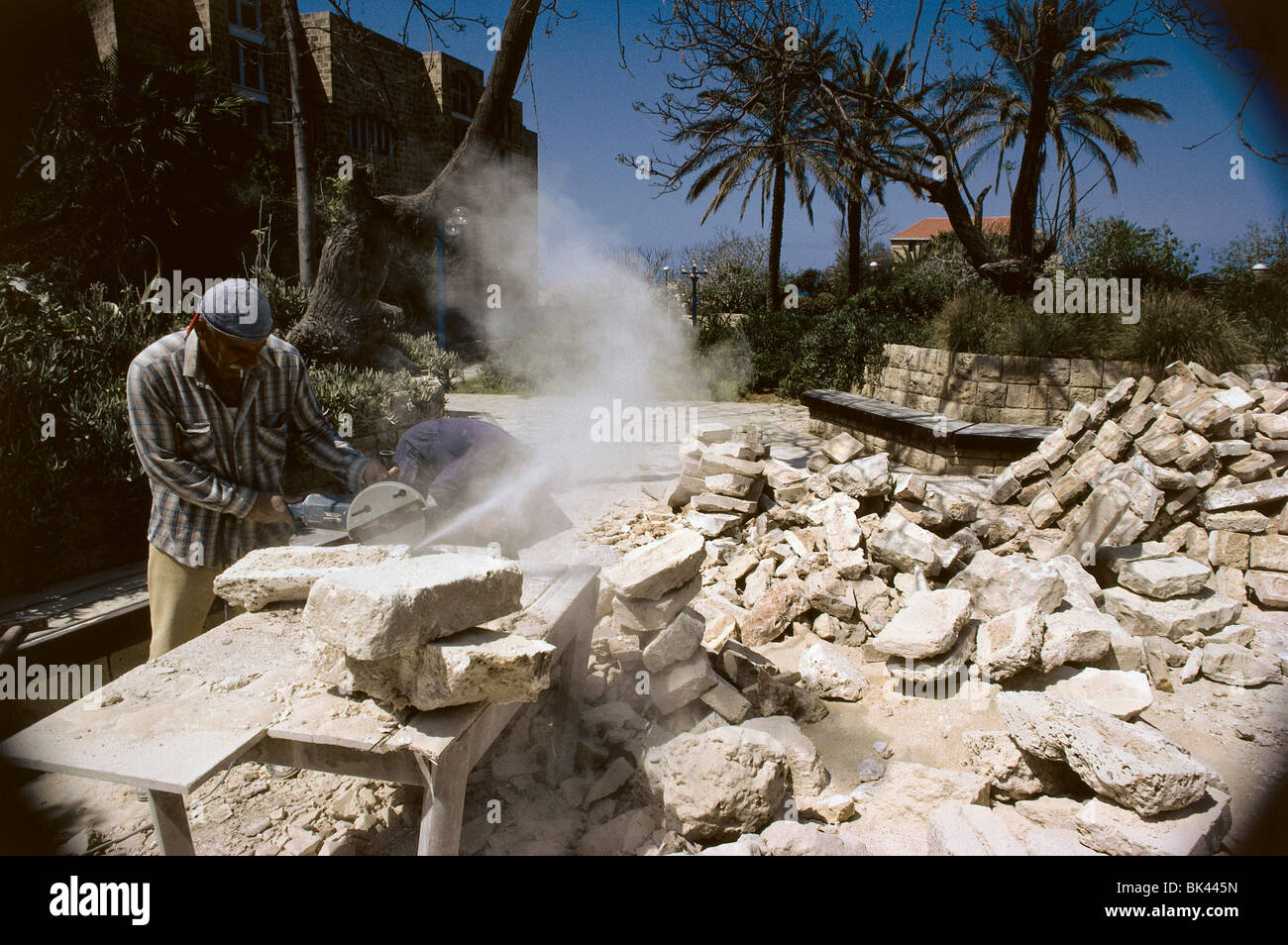 Travailleur de la construction en pierre de coupe avec une scie électrique, Israël Banque D'Images